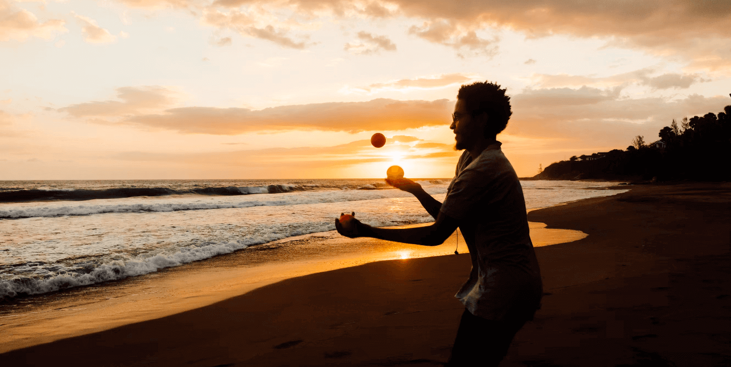 A man juggling on the beach