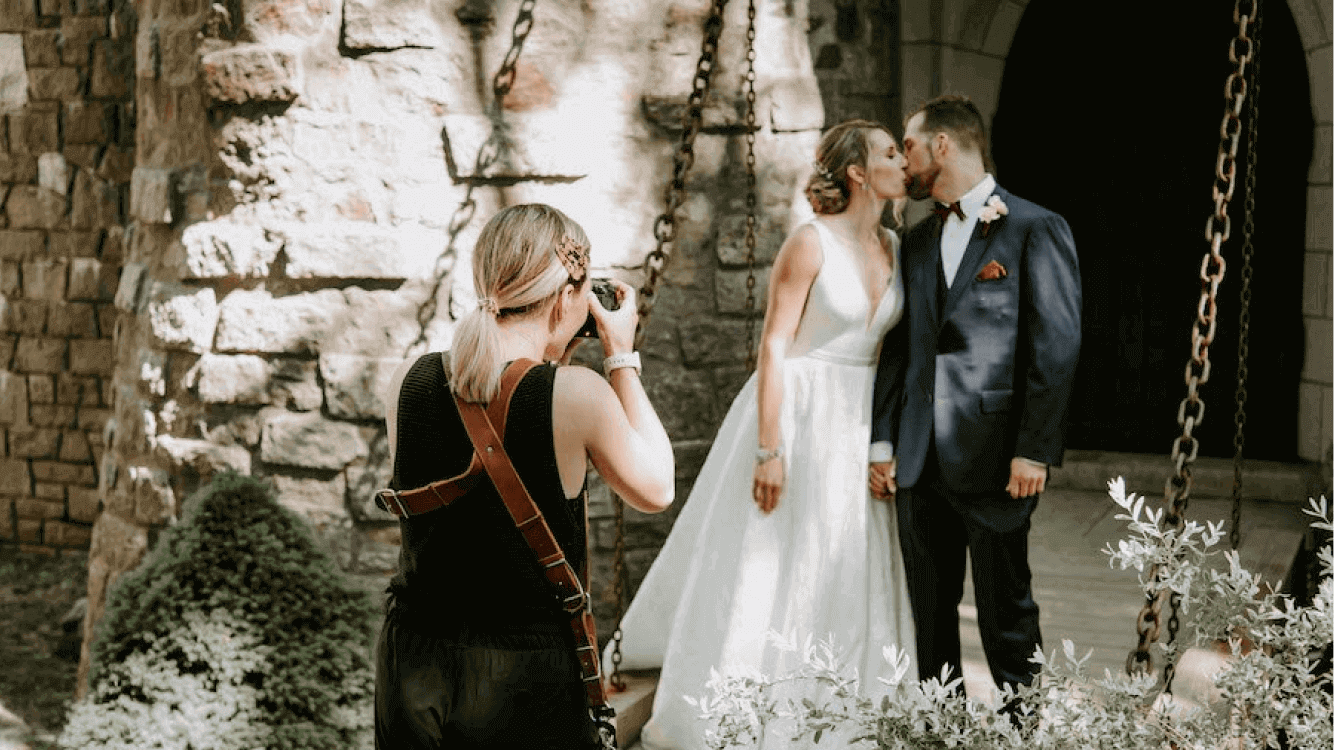 A wedding photographer shooting a happy couple on their wedding day